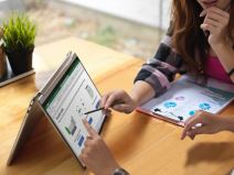 Devojka nešto objašnjava na Lenovo Yoga 9i laptopu na stolu