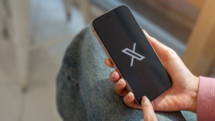Mobilni telefon na kojem je prikazan logo mreže X