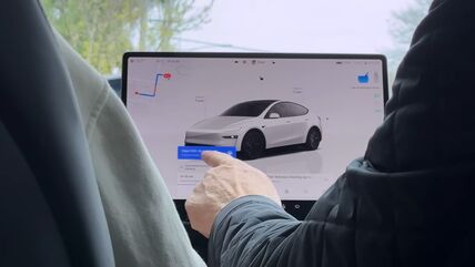 Čovek pritiska dugme za Full Self Driving režim u Tesla automobilu