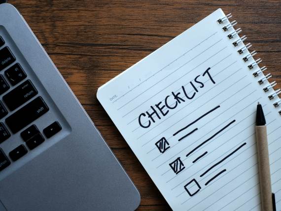 Spisak stvari u svesci sa olovkom i računarom pored