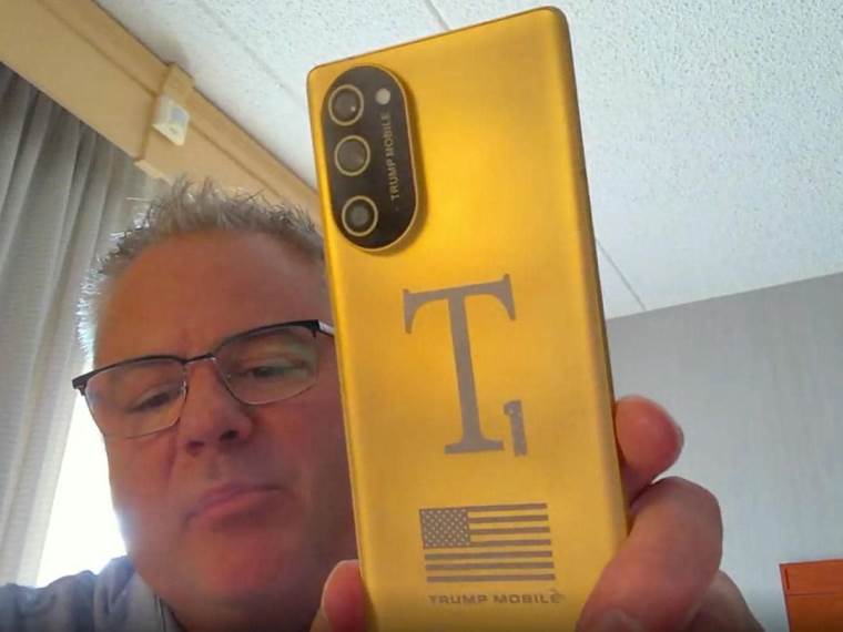 Erik Tomas pokazuje Trump Mobile T1 Phone