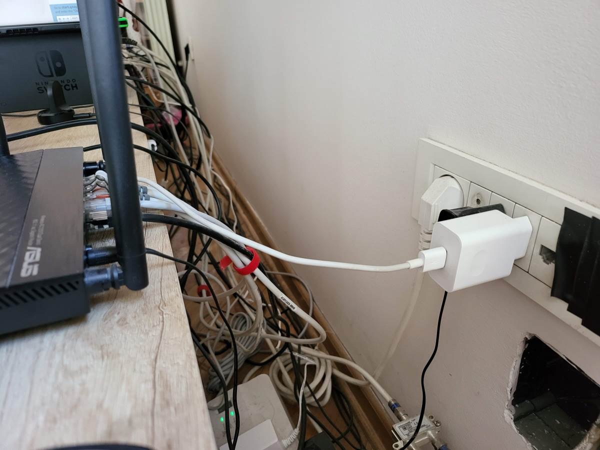 Kablovi iza police i utičnica sa punjačima